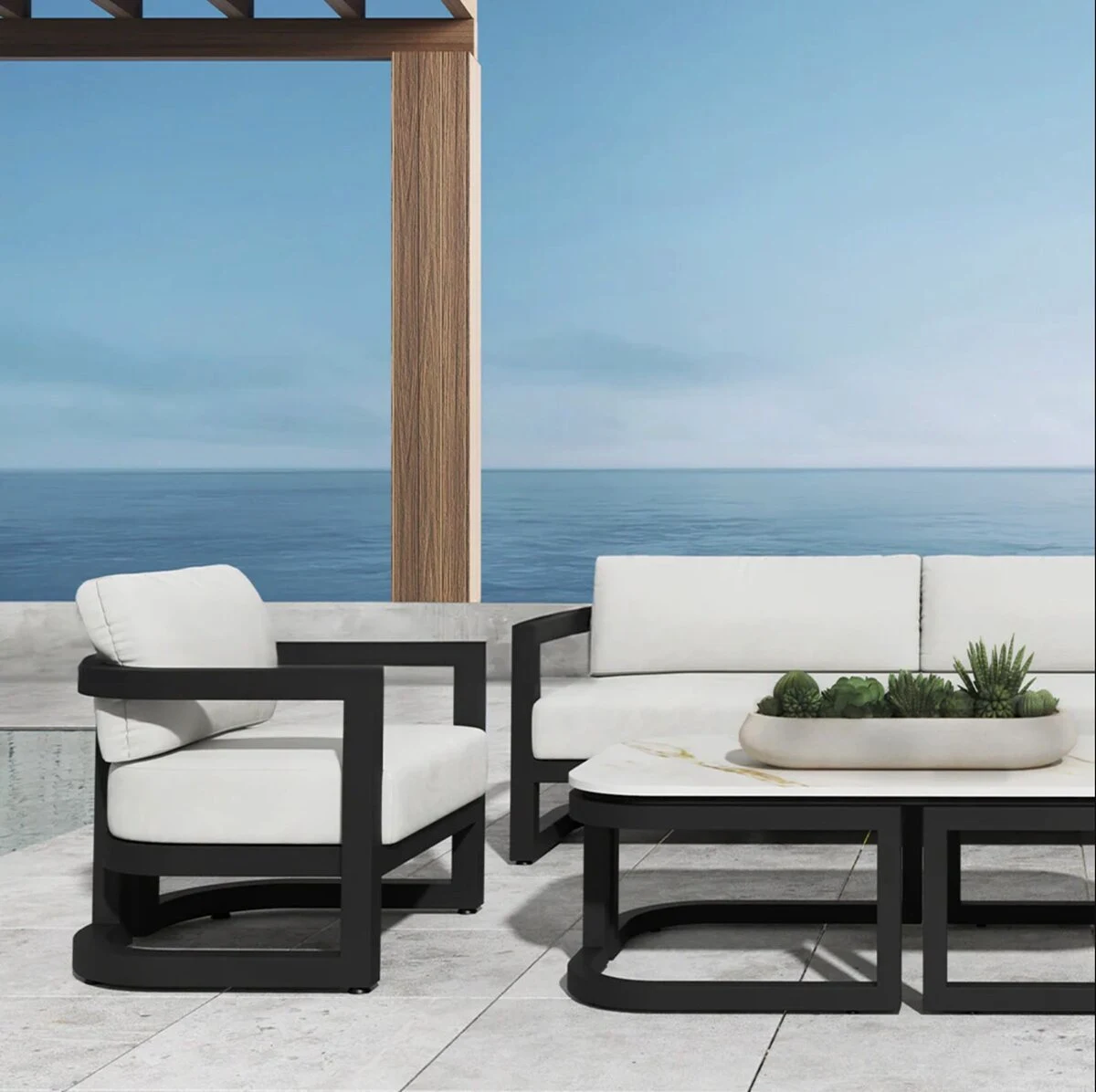 A gray aluminum outdoor sofa and lounge chairs with neutral cushions on a modern patio with sliding glass doors.
