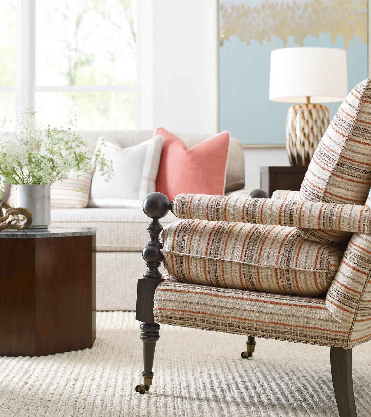 Striped accent chair with turned wood legs in a bright living room