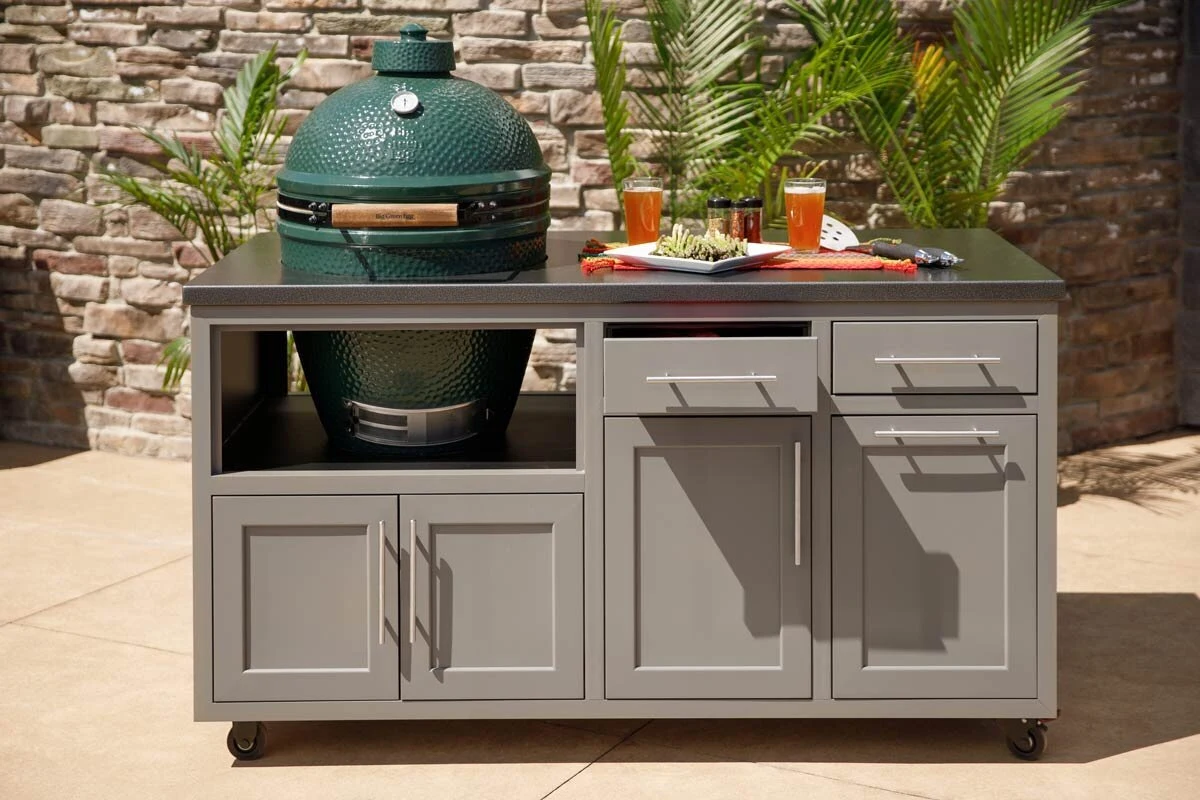Custom outdoor kitchen with green egg grill and coastal style cabinetry on a modern patio.