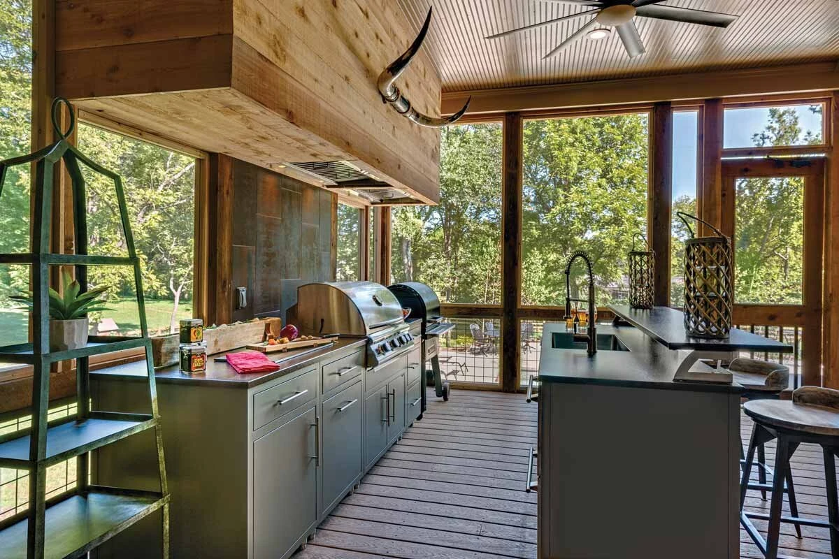 Custom outdoor kitchen with stainless steel grill and cabinetry on a covered patio with wood ceiling. Shop near Hayden Lake.