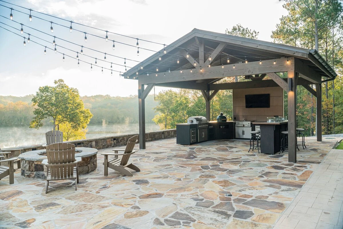 Custom outdoor kitchen with stainless steel grill and cabinetry overlooking a landscaped backyard. Shop near Hayden Lake.