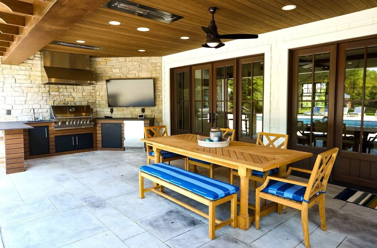 Custom outdoor kitchen with stainless steel grill, cabinetry, and bar seating in a warm outdoor entertaining space. Available near Sandpoint and Spokane.