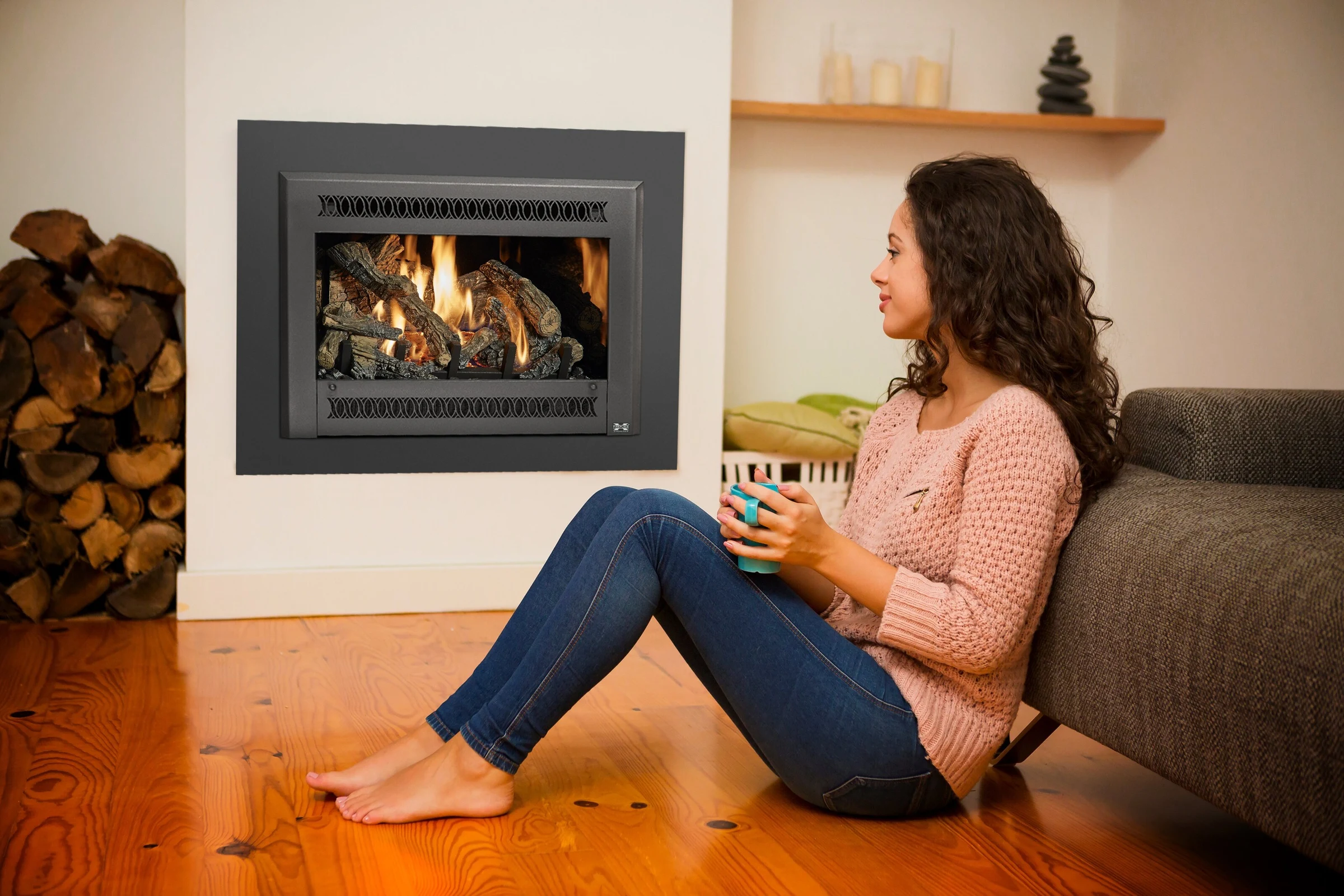 Woman relaxing by a Fireplace Xtrordinair 32 DVS gas insert with a modern surround.