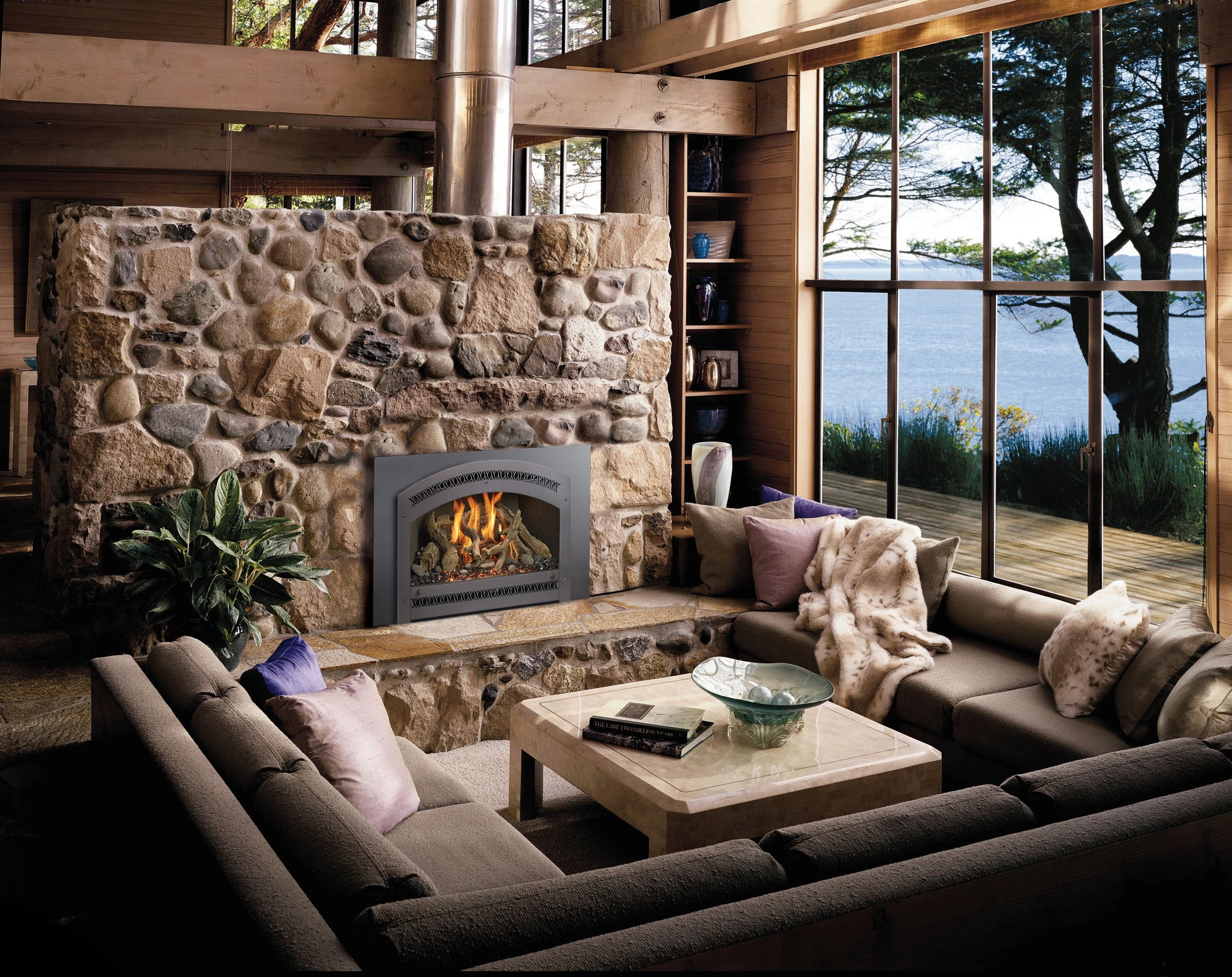 Fireplace Xtrordinair 34 DVL Deluxe Ember-Glo gas insert installed in a stone fireplace surround in a living room.
