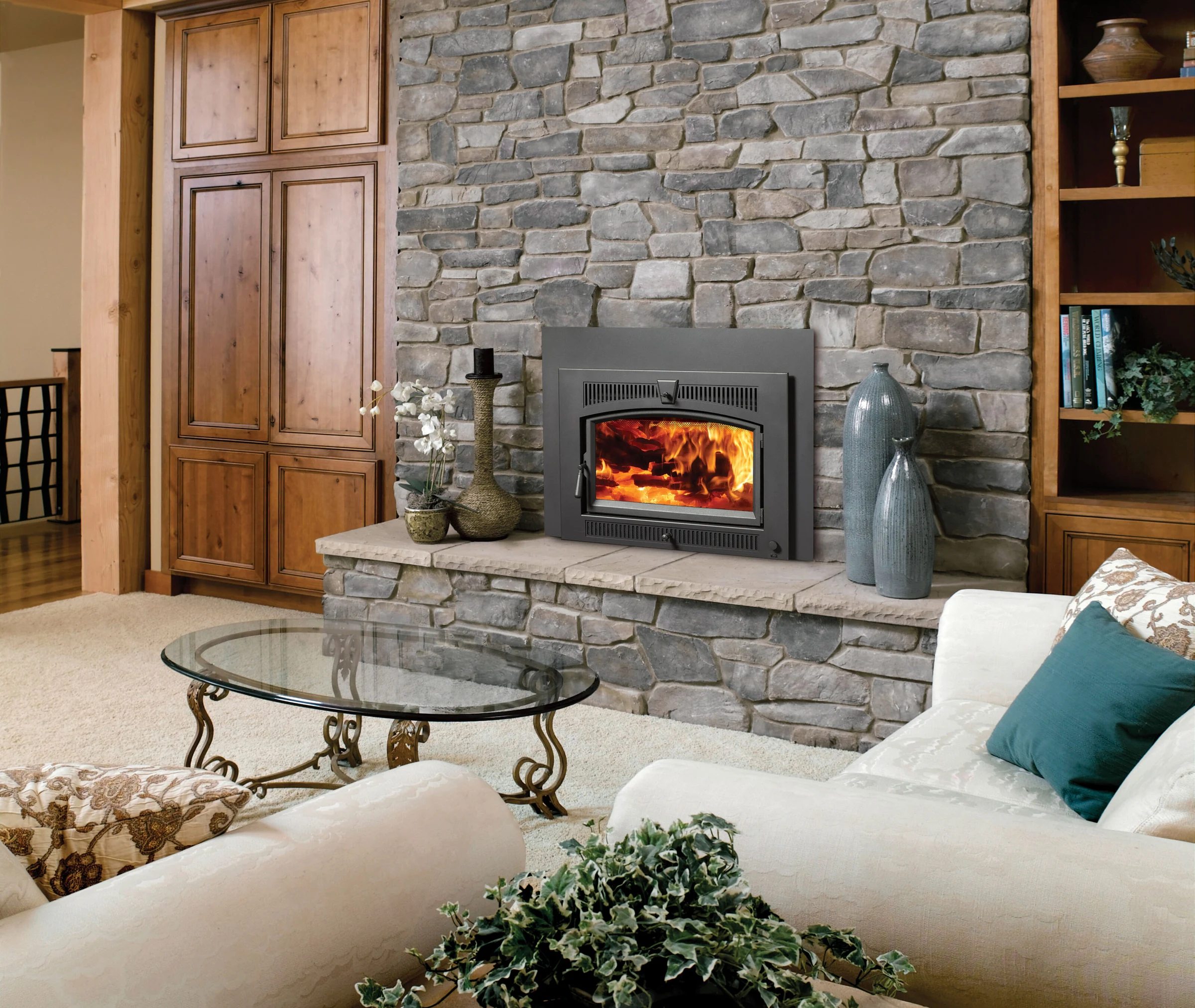 Fireplace Xtrordinair Large Flush NexGen-Hybrid wood insert in a stone surround in a living room setting.