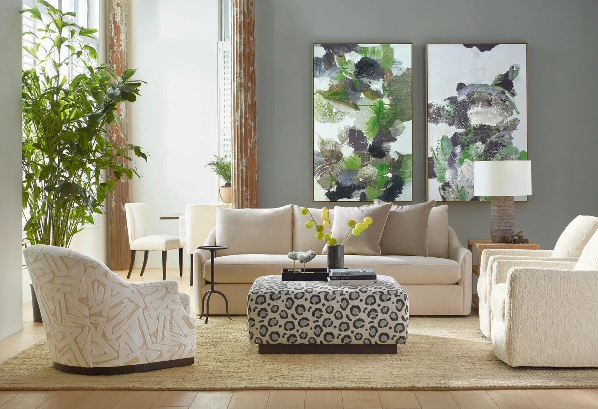 Cream sofa with a patterned ottoman and green abstract art