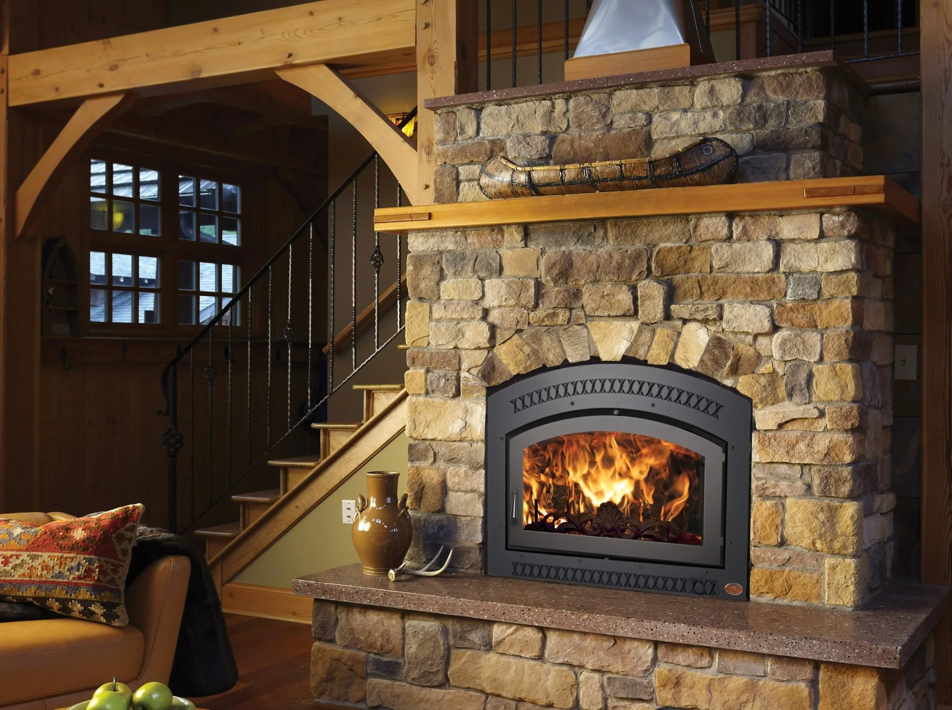 Wood fireplace set in a stone hearth in a timber-frame home