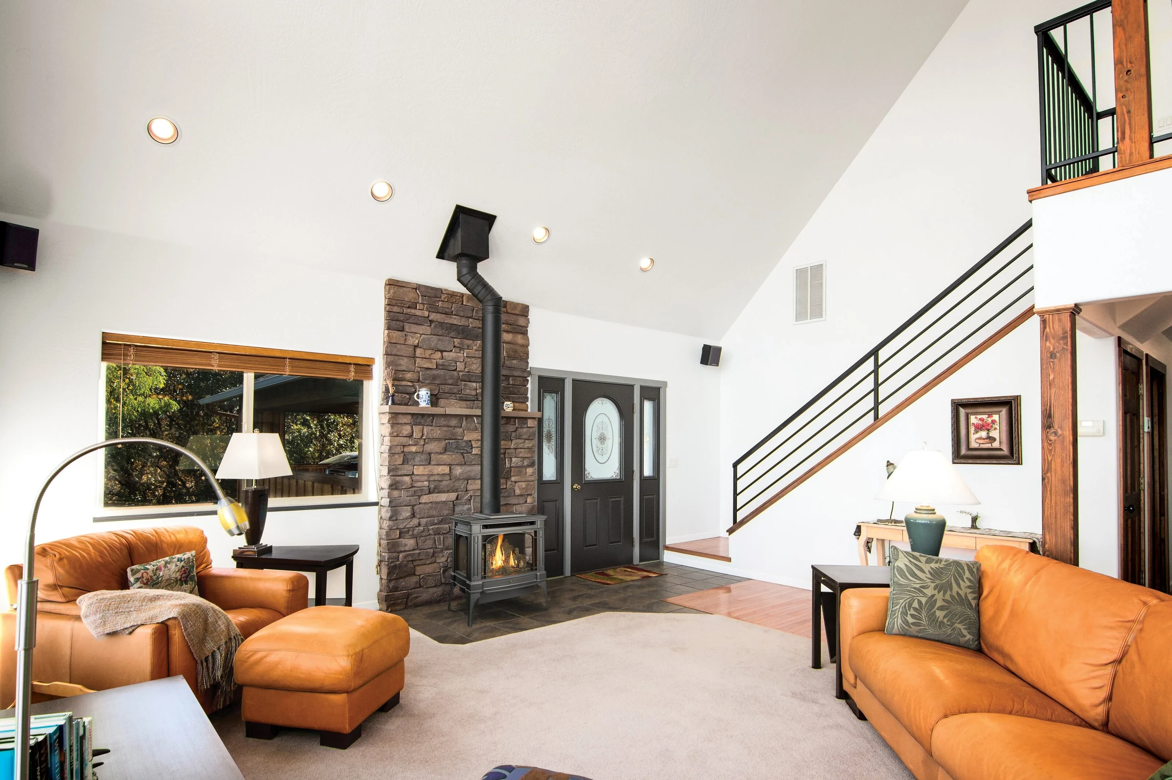 A Lopi Berkshire Bay Window gas stove installed in a contemporary living space with stone tile flooring and neutral decor.