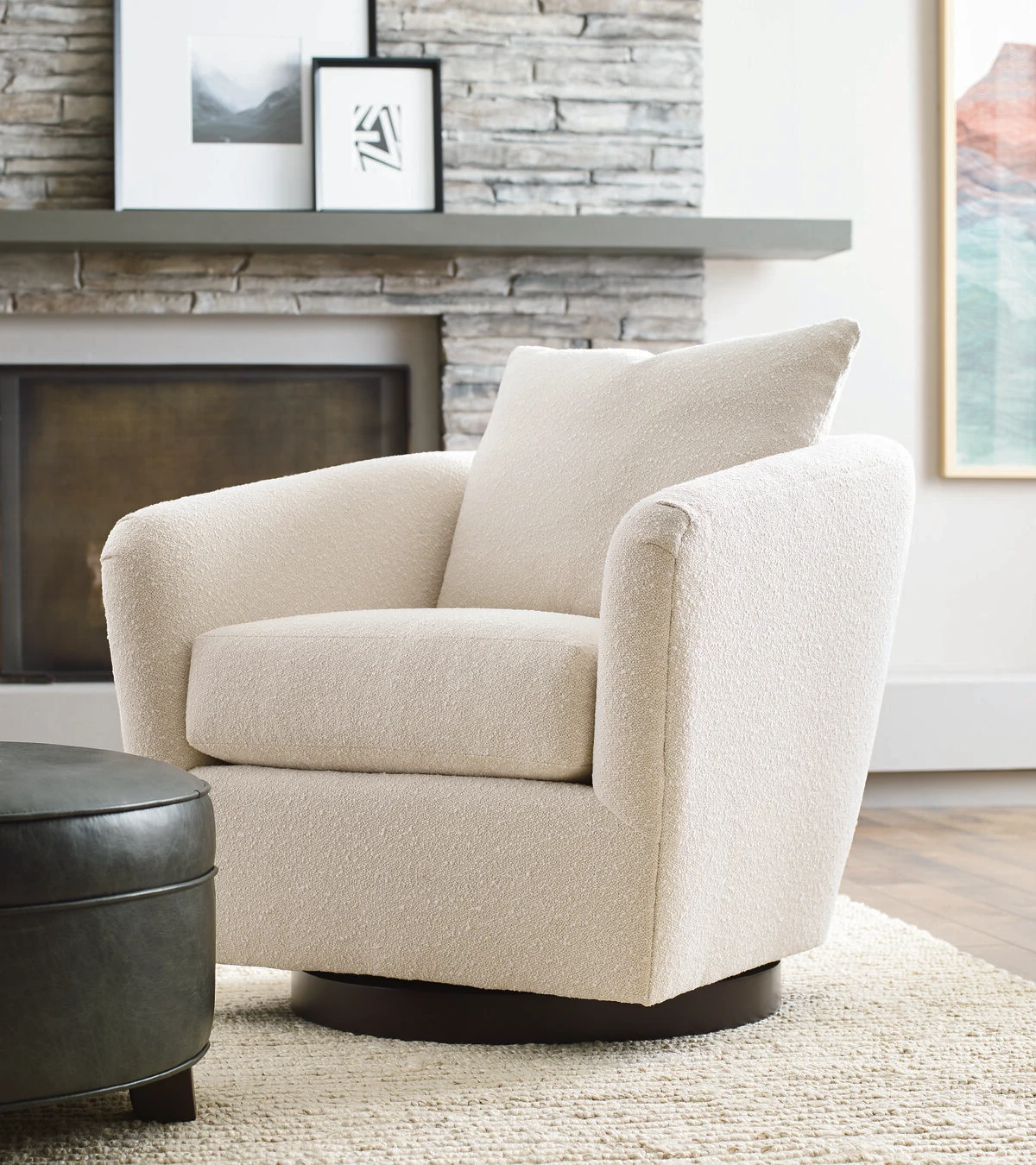 Cream swivel chair in front of a stone fireplace