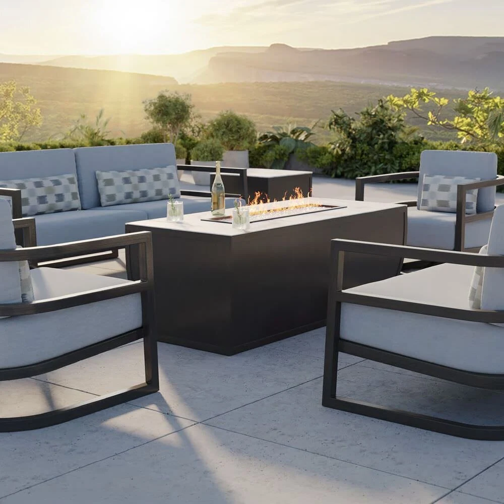 Outdoor lounge seating around a fire table at sunset