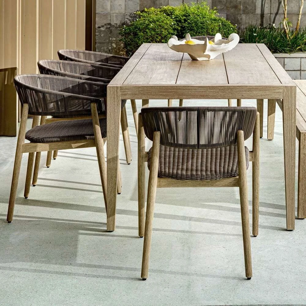 Teak outdoor dining table with woven rope chairs