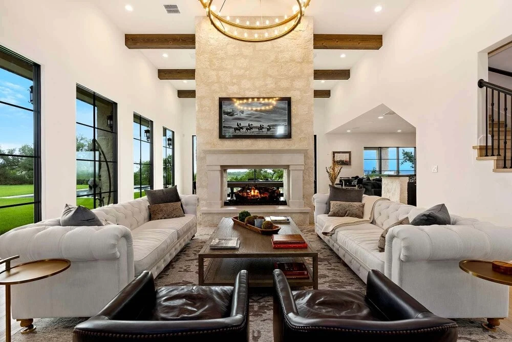 A masonry fireplace with an ornate arched surround and mantel in a warm, traditionally styled outdoor entertaining space.