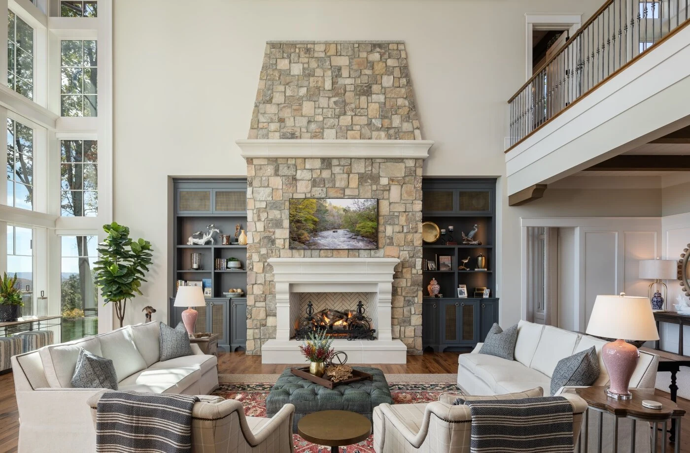 A floor-to-ceiling stacked stone fireplace surround with a linear gas insert and floating wood mantel in a bright living room.