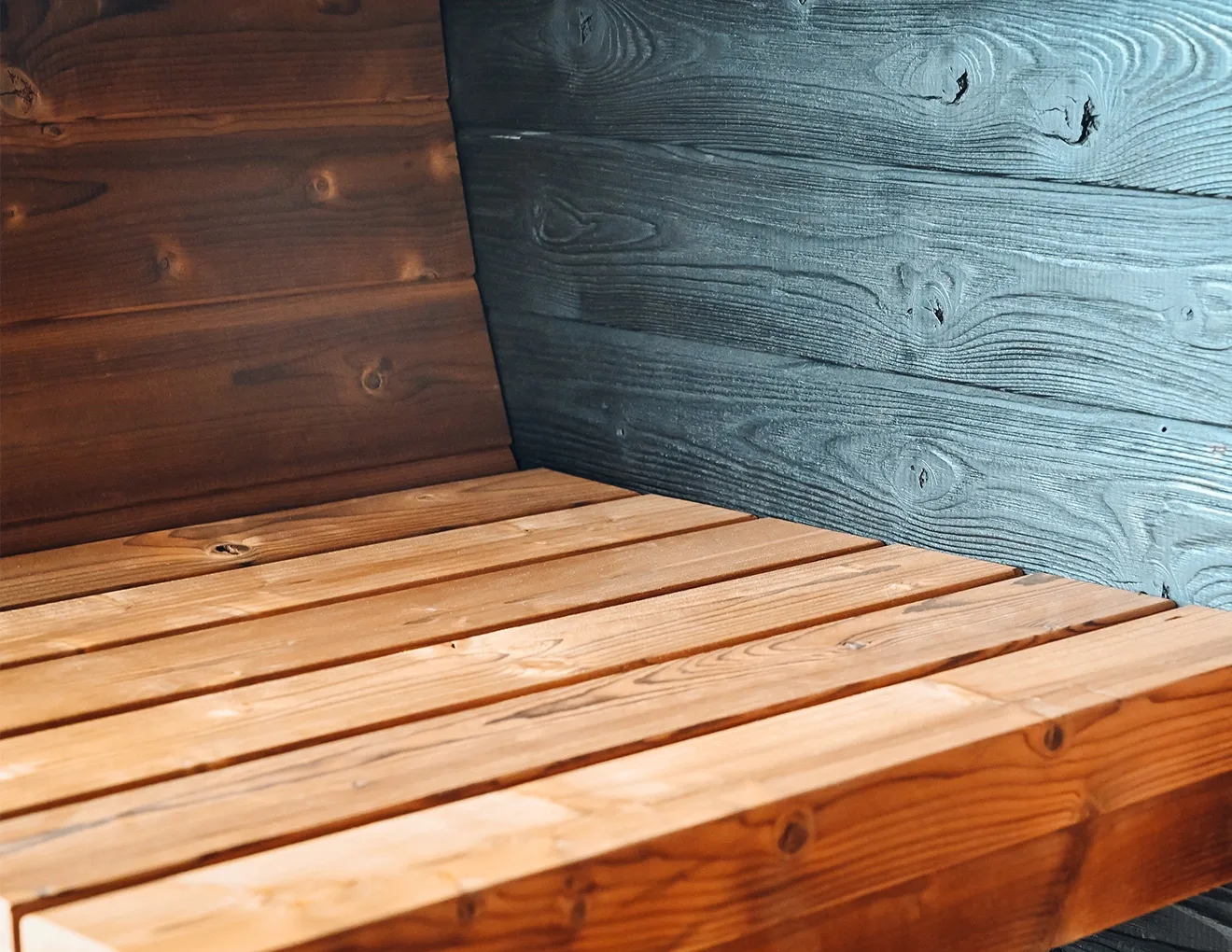 Thermory Ignite Barrel Sauna bench detail against charred Ignite walls