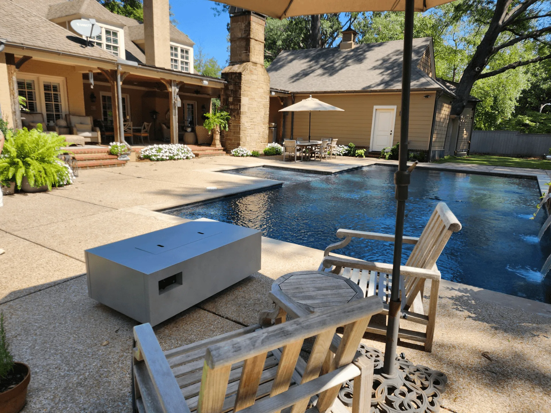 Warming Trends AON rectangle fire table in Charcoal beside a backyard pool